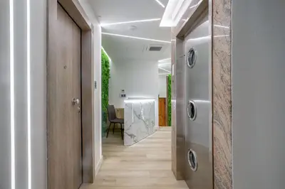 a hallway with wood floors and a door with a table at Porto Pireo by SuperHost365 Leosthenous in Piraeus