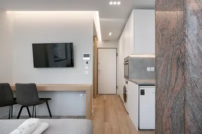 a room with a kitchen and a desk with a television at Porto Pireo by SuperHost365 Leosthenous in Piraeus
