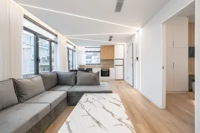 a living room with a couch and a kitchen at Porto Pireo by SuperHost365 Leosthenous in Piraeus