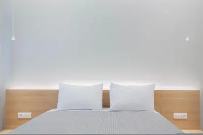 a bed with white sheets and pillows in a room at Porto Pireo by SuperHost365 Leosthenous in Piraeus