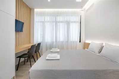 a bedroom with a bed and a table and chairs at Porto Pireo by SuperHost365 Leosthenous in Piraeus