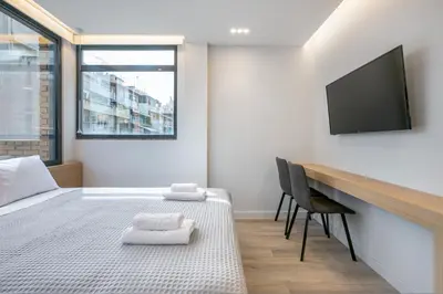 a bedroom with a bed and a desk and a television at Porto Pireo by SuperHost365 Leosthenous in Piraeus