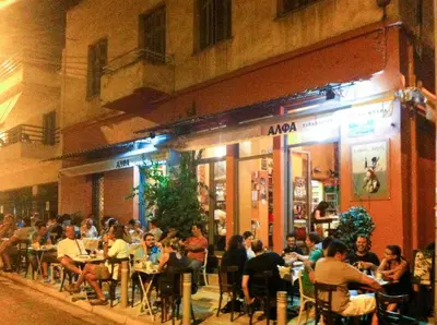 a group of people sitting outside a restaurant at night at Athens loft 5 min from Monastiraki metro stop in Athens