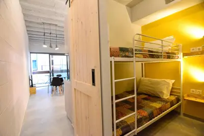 a room with bunk beds and a hallway with a table at Athens loft 5 min from Monastiraki metro stop in Athens