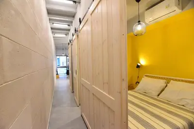 a bedroom with a bed with a yellow wall at Athens loft 5 min from Monastiraki metro stop in Athens
