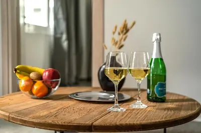 a table with two glasses of white wine and a bottle at City Center Suite in Athens