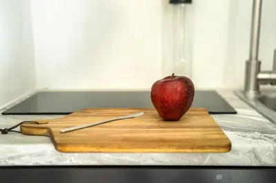 an apple sitting on a cutting board with a knife at City Center Suite in Athens