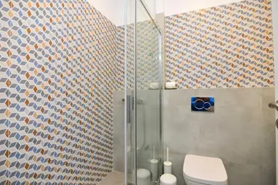 a bathroom with a toilet and a glass shower at Athens industrial design apt 5 min from Metro in Athens