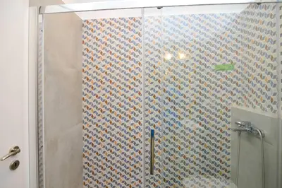 a bathroom with a shower with a tiled wall at Athens industrial design apt 5 min from Metro in Athens