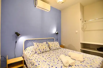 a bedroom with a bed with a blue wall at Athens industrial design apt 5 min from Metro in Athens