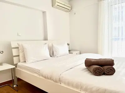 a bedroom with a white bed with towels on it at Pratinou 1B/R apartment in Athens