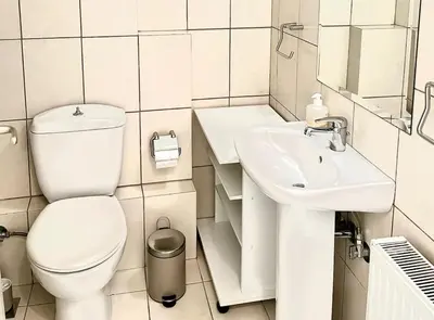 a white bathroom with a toilet and a sink at Pratinou 1B/R apartment in Athens