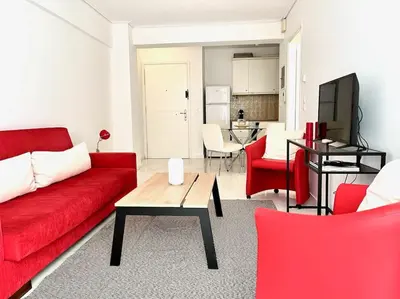 a living room with a red couch and red chairs at Pratinou 1B/R apartment in Athens