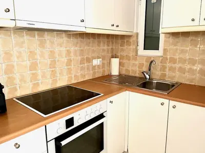 a kitchen with white cabinets and a sink at Pratinou 1B/R apartment in Athens