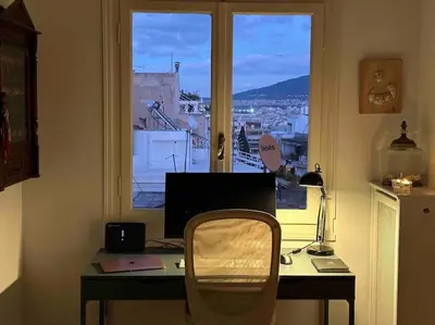 a desk with a computer in front of a window at Beautiful 94 sq.m apartment with view over Athens in Athens