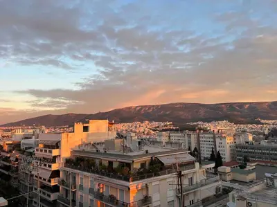 a view of a city at sunset with buildings at Beautiful 94 sq.m apartment with view over Athens in Athens