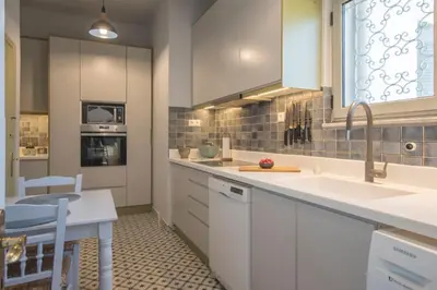 a kitchen with white cabinets and a sink at Beautiful 94 sq.m apartment with view over Athens in Athens