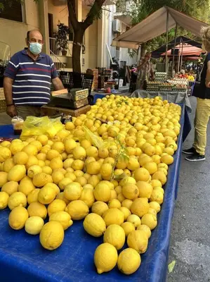 a pile of lemons on a table at a market at Beautiful 94 sq.m apartment with view over Athens in Athens