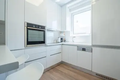a white kitchen with white cabinets and a window at Athens Riviera Aelia Luxury Suite By The Sea in Athens