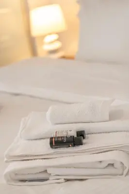 a group of white towels on a bed with a flashlight at Athens Riviera Aelia Luxury Suite By The Sea in Athens