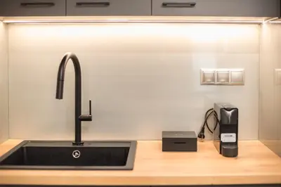 a kitchen sink with a faucet next to a phone at Newly Renovated Loft 1 min walk from metro by Cloudkeys in Athens