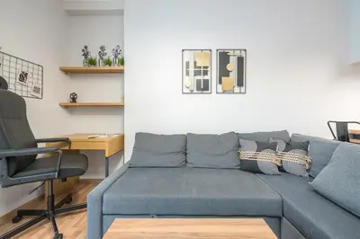 a living room with a blue couch and a desk at Newly Renovated Loft 1 min walk from metro by Cloudkeys in Athens