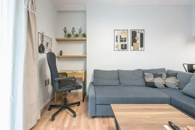 a living room with a blue couch and a desk at Newly Renovated Loft 1 min walk from metro by Cloudkeys in Athens