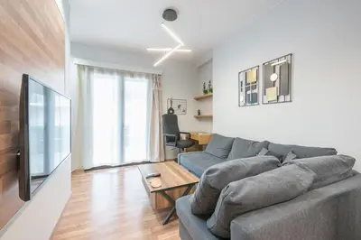 a living room with a couch and a table at Newly Renovated Loft 1 min walk from metro by Cloudkeys in Athens