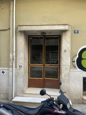 a motorcycle parked in front of a building with a door at Newly Renovated Loft 1 min walk from metro by Cloudkeys in Athens