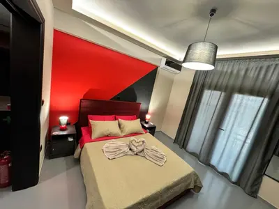 a bedroom with a red headboard and a bed at Samurai apartments -Catrin- in Koropíon