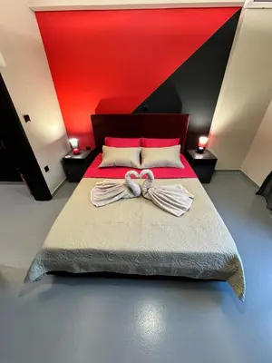 a bedroom with a bed with a red head board at Samurai apartments -Catrin- in Koropíon
