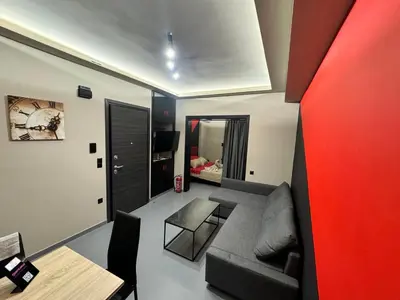 a living room with a couch and a red wall at Samurai apartments -Catrin- in Koropíon