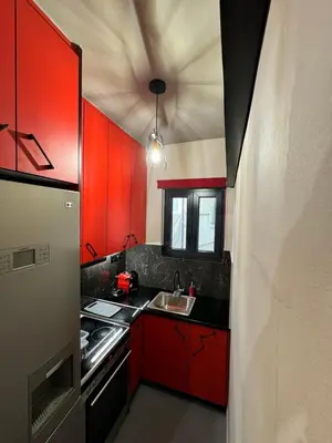 a kitchen with red cabinets and a sink at Samurai apartments -Catrin- in Koropíon