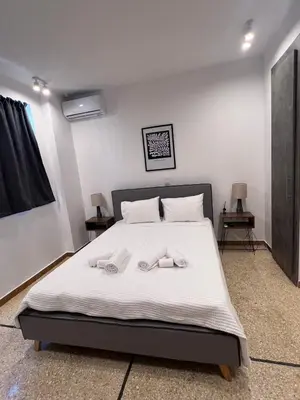 a bedroom with a bed with two towels on it at 2BDR q in Athens