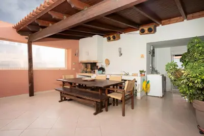 a large kitchen with a wooden table and chairs at Maria's Airport Apartment, 4' metro, 10' airport, 15' beach, 40' city center in Koropíon