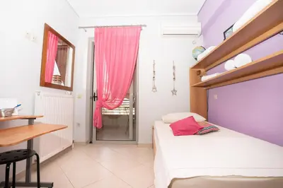 a bedroom with a bed and a table and a desk at Maria's Airport Apartment, 4' metro, 10' airport, 15' beach, 40' city center in Koropíon