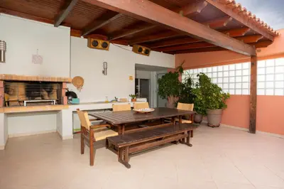 a kitchen and dining room with a wooden table and bench at Maria's Airport Apartment, 4' metro, 10' airport, 15' beach, 40' city center in Koropíon