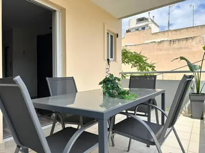 a dining table and chairs on a patio with a window at D150 Orange & New Life - Cloud9 in the city in Athens