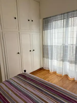 a bedroom with a bed and white cabinets and a window at Комната с общей баней karolou 10 in Athens