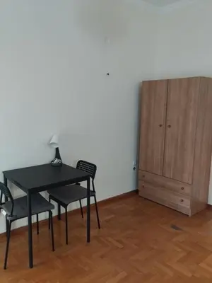 a table and two chairs and a cabinet in a room at Комната с общей баней karolou 10 in Athens