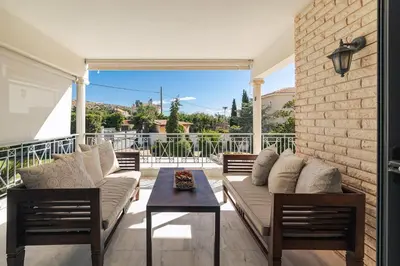 a patio with a couch and chairs and a table at Lagonisi Luxury Escape in Lagonissi