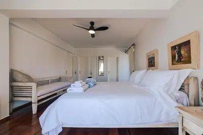 a bedroom with a large white bed and a couch at Lagonisi Luxury Escape in Lagonissi