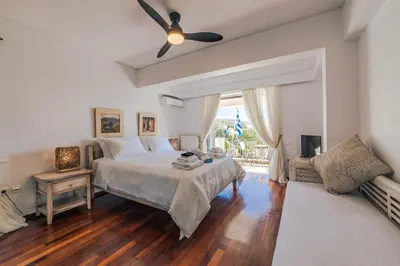 a bedroom with a bed and a ceiling fan at Lagonisi Luxury Escape in Lagonissi