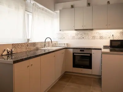 a kitchen with white cabinets and a sink at Prasa in Piraeus