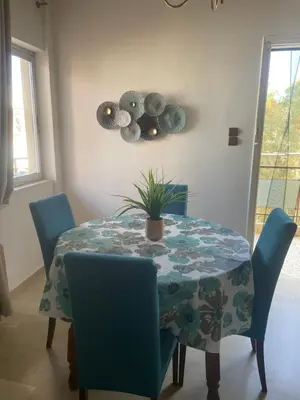 a dining room table and chairs with a plant on it at Seaside Argo apartment in Porto Rafti