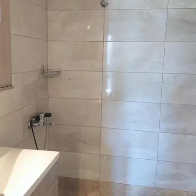 a bathroom with a shower with a white sink at Sunny apartment in Acropolis in Athens