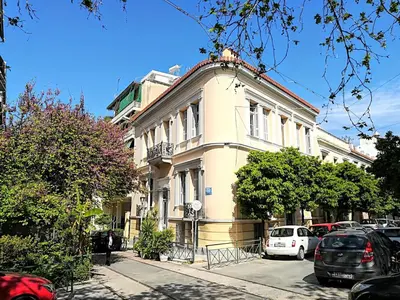 a white building with cars parked in front of it at Sunny apartment in Acropolis in Athens