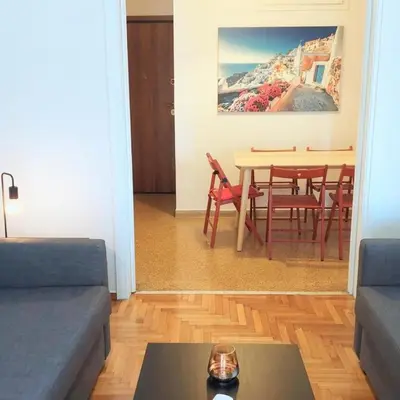 a living room with a couch and a table with chairs at Sunny apartment in Acropolis in Athens
