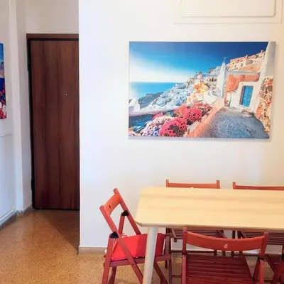 a table and chairs with a picture on the wall at Sunny apartment in Acropolis in Athens