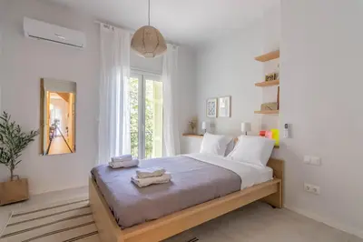 a white bedroom with a large bed with towels on it at ARIS Central Athens in Athens